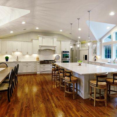 Giant white gourmet kitchen with wood floors